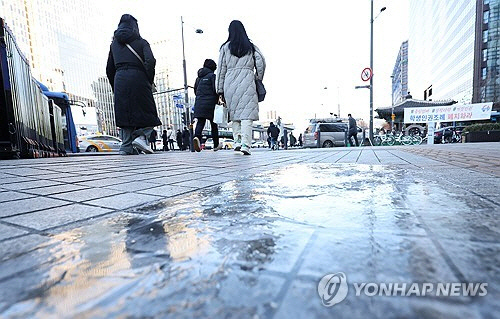 서울 아침 기온이 영하 7도를 기록해 추운 날씨를 보인 15일 오전 서울 종로구 광화문네거리 인근 인도에 얼음이 얼어 있다.  [연합뉴스]